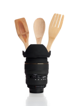 camera lens with kitchen tools inside it on white background